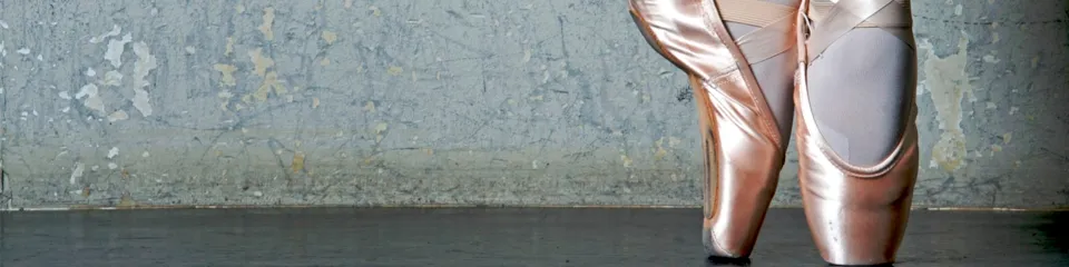 Rosa Ballettschuhe vor einer Wand